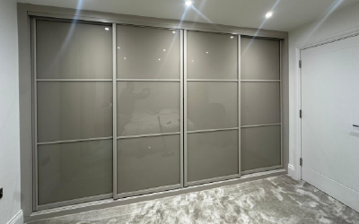 Boutique-style dressing room featuring glass-fronted bespoke wardrobes.
