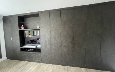 Custom eaves storage solution with white shaker doors in a loft bedroom.