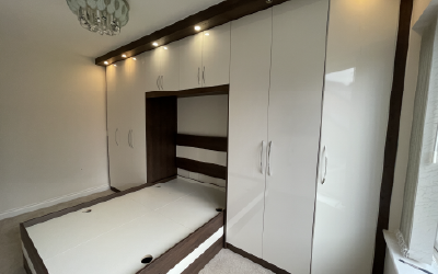 Fitted bedroom suite with overbed storage bridges and bedside cabinets.