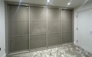 Boutique-style dressing room featuring glass-fronted bespoke wardrobes.