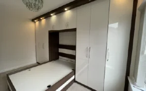 Fitted bedroom suite with overbed storage bridges and bedside cabinets.
